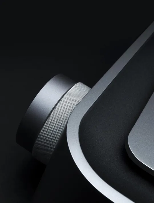 Knurled aluminium dial against matte black, a reference for how machined texture and soft radii read in low-key product lighting.